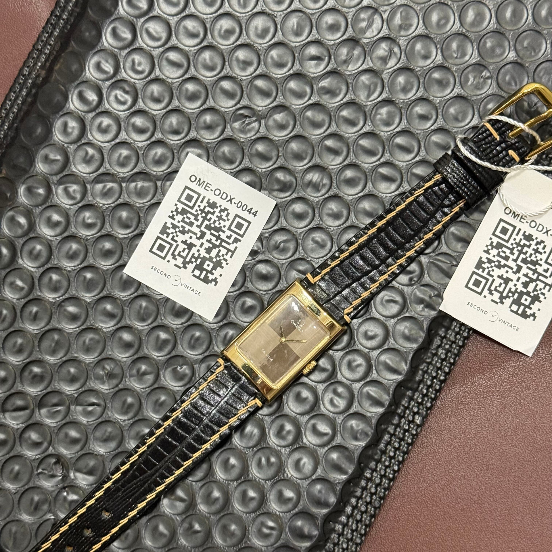 Gold Omega De Ville on a leather strap with two Second Vintage QR reference cards