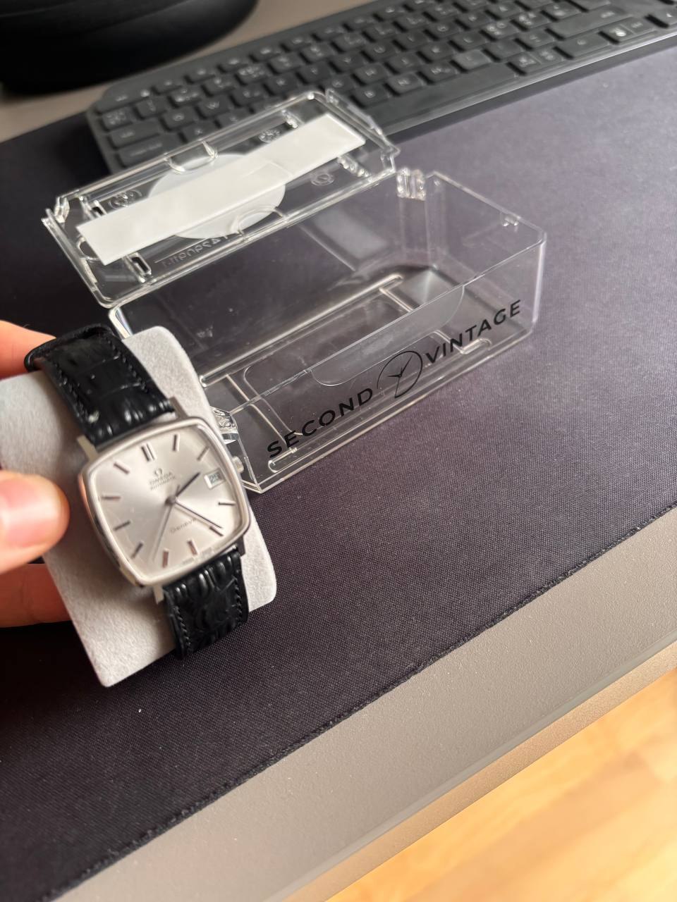 Vintage Omega De Ville held beside its engraved Second Vintage case