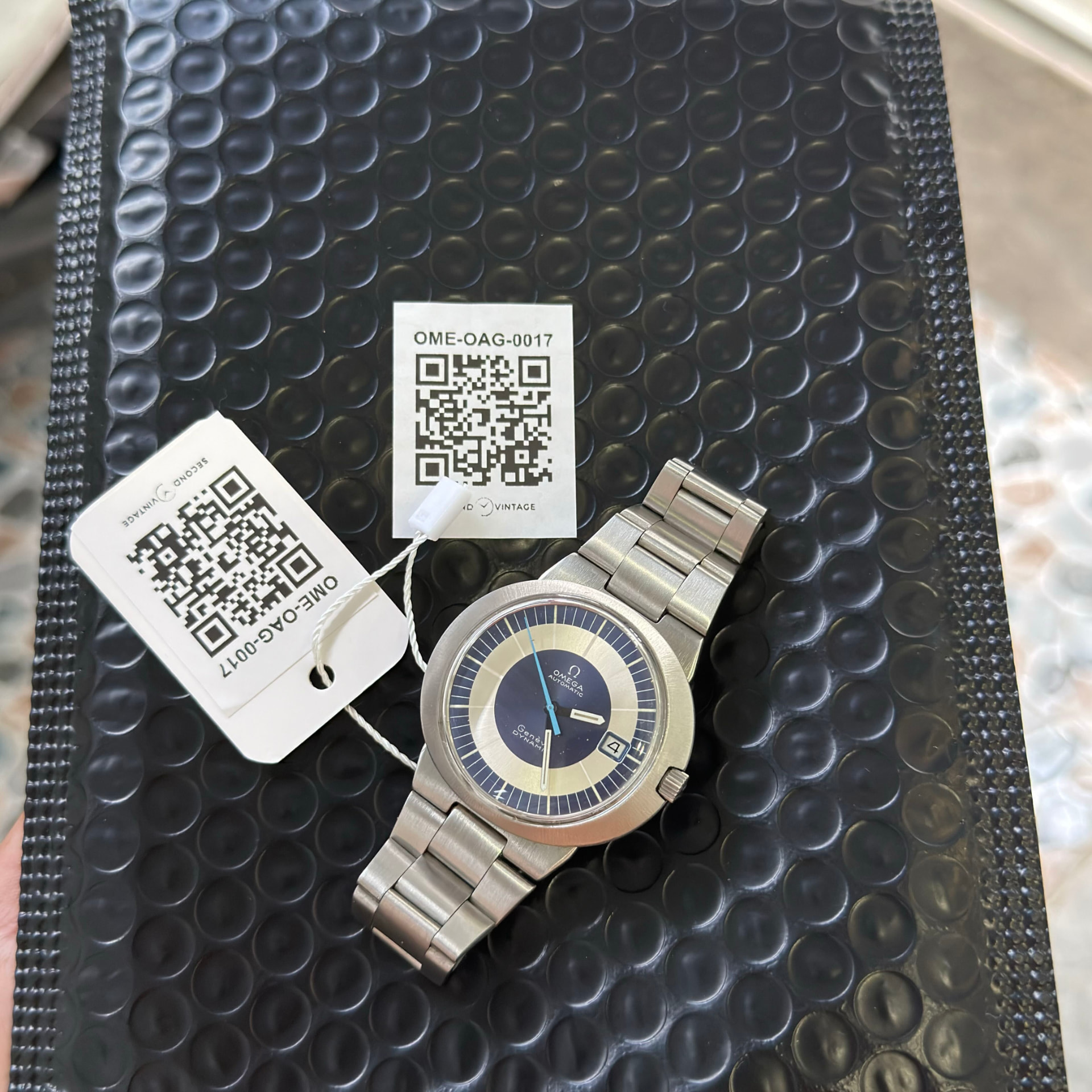 Omega Dynamic on steel bracelet beside its Second Vintage QR reference tags